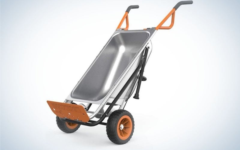 A small silver wheelbarrow with two black wheels as well as a silver structure and a support end at its bottom orange.