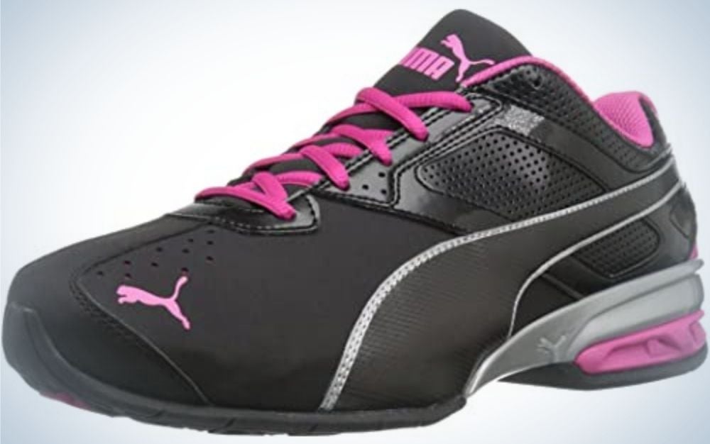 A black sneakers with pink laces and the pink brand mark on it.