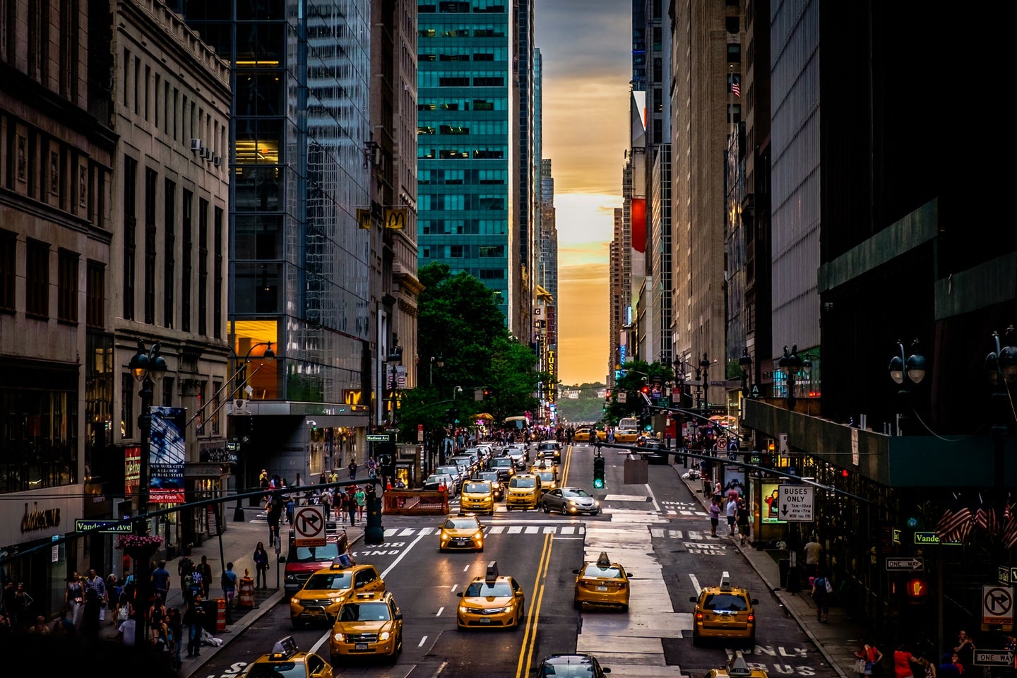 Taxis and cars driving down a New York City street
