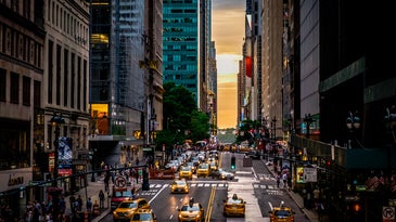 Taxis and cars driving down a New York City street