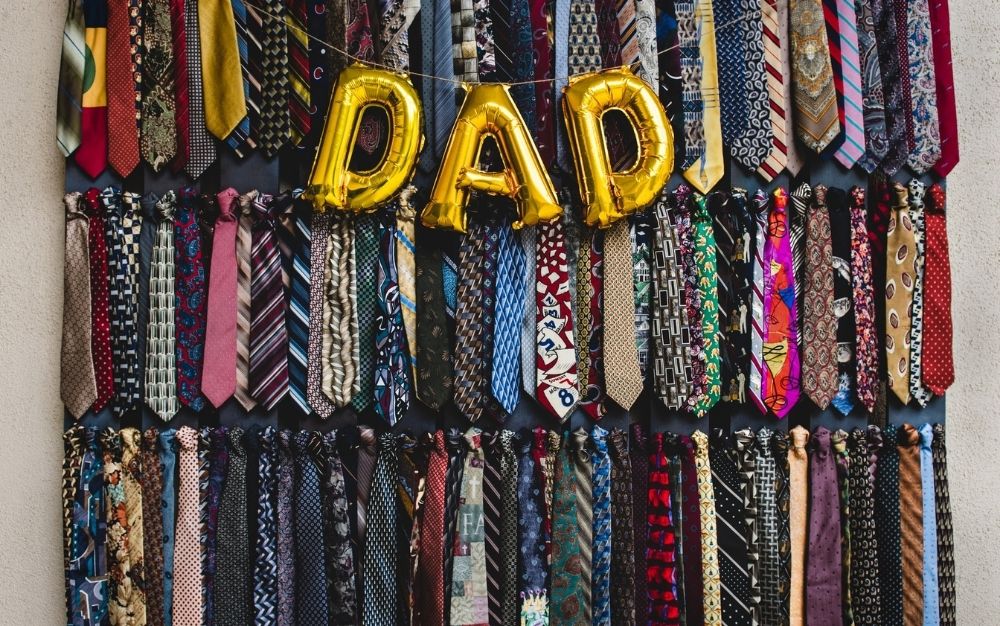 A wardrobe all with collars for men, different colors and models, as well as some balloons that write DAD.