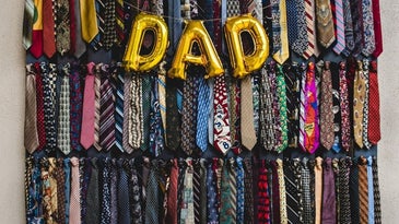 A wardrobe all with collars for men, different colors and models, as well as some balloons that write DAD.