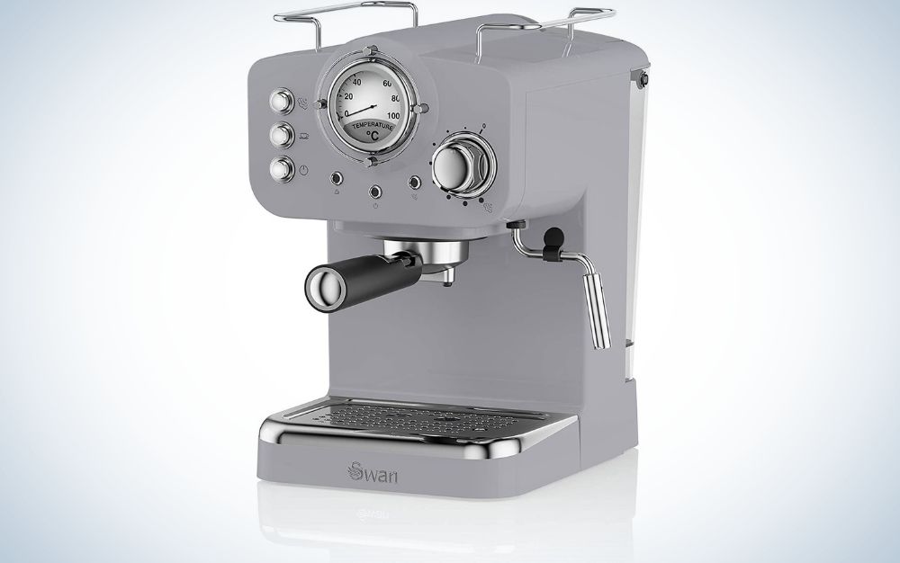 A coffee machine for making gray coffee and two compasses that indicate the level of graduation, as well as buttons attached to them at the top of the machine, as well as a black lever in the middle of it and a metal pipe for the coffee outlet.
