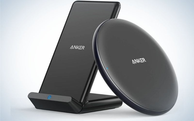 Two chargers for cordless phones which are all black and one in a circular shape and the other in a rectangular shape.