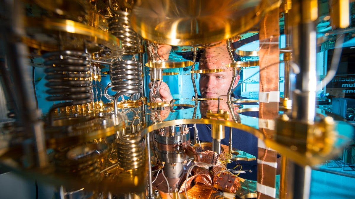 A man looks through the cooling mechanism of a quantum computer.