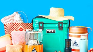 Teal Yeti cooler and other travel gear on a blue background