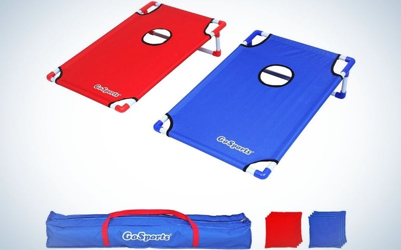 Two portable Cornhole toss games, one red and the other blue and a blue bag underneath.