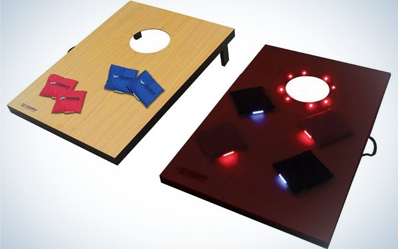 Two square shapes, one wood color and the other cherry color, both with a circular hole on top of them and between them there are blue and red pillow shapes, and on the other you can see bright lights of different colors.