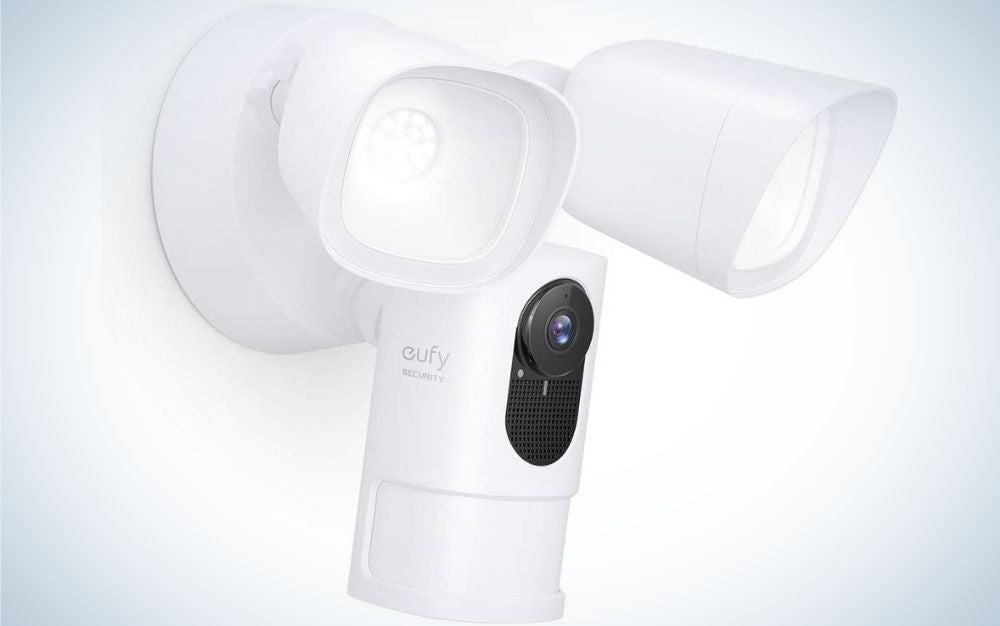 A white wall camera with two heads and elements as well as a black space in the central part of the camera body.