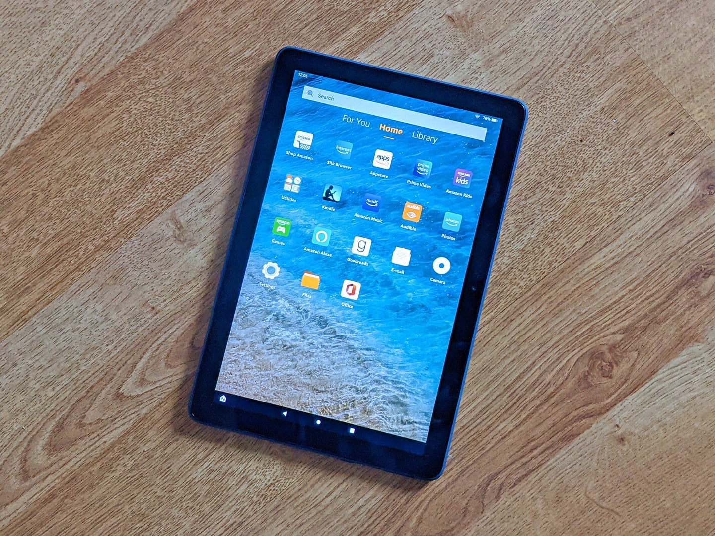 An Amazon Fire HD tablet on a wood floor.