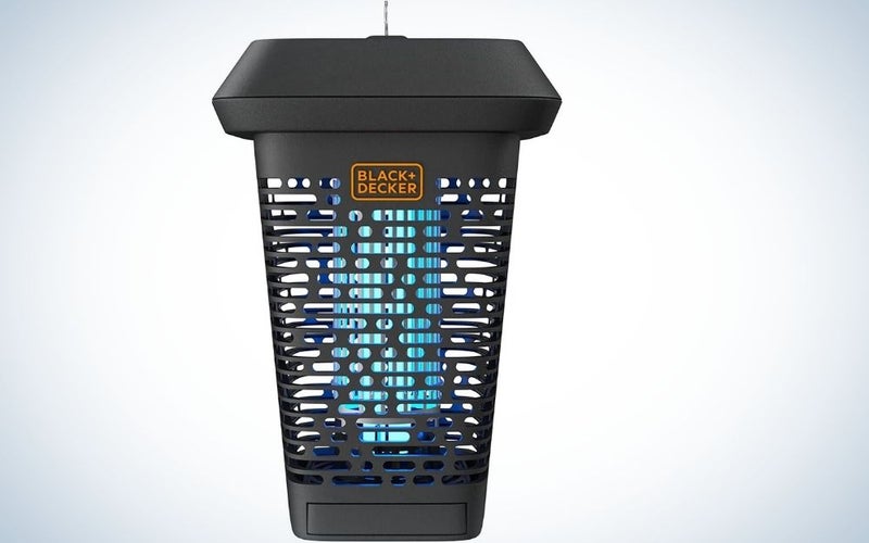 A bug zapper in the shape of a large glass which is black and has blue holes in it.