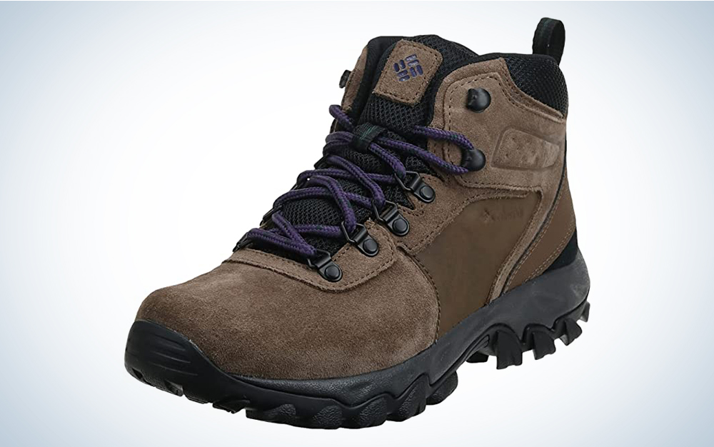 A pair of brown hiking boots against a blue and white gradient background