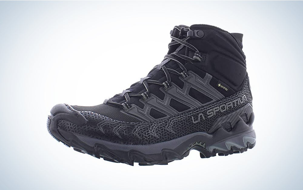A pair of black backpacking hiking shoes on a blue and white background