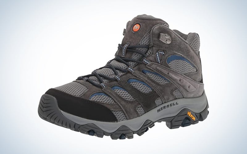 A pair of grey sustainable hiking boots on a blue and white gradient background