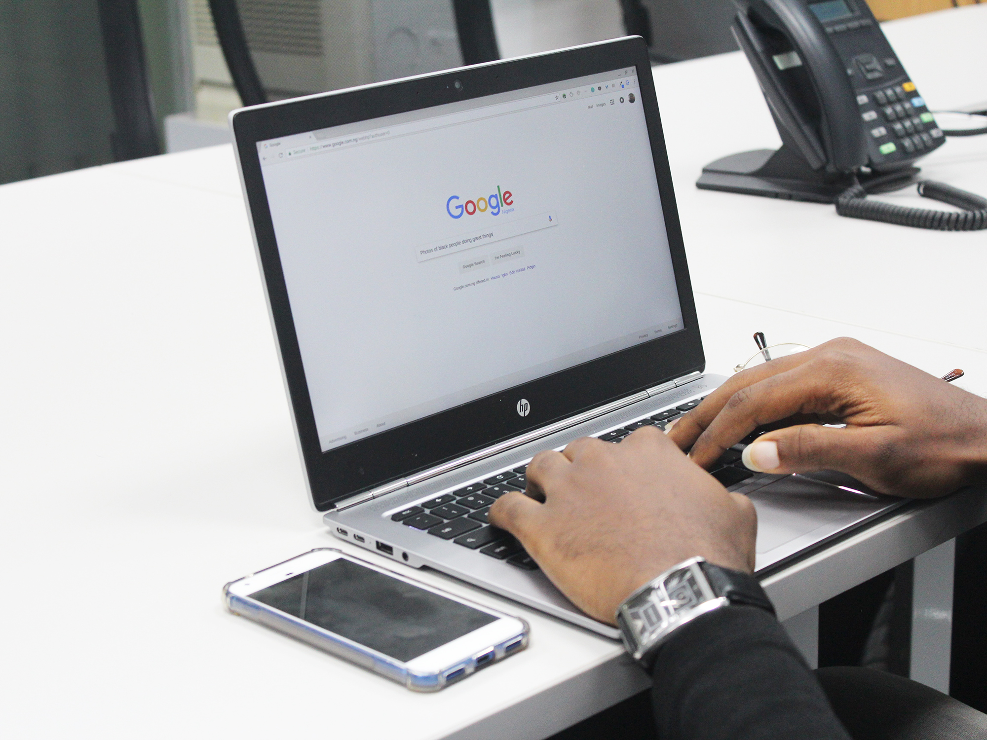 A person using a laptop computer with Google on the screen.