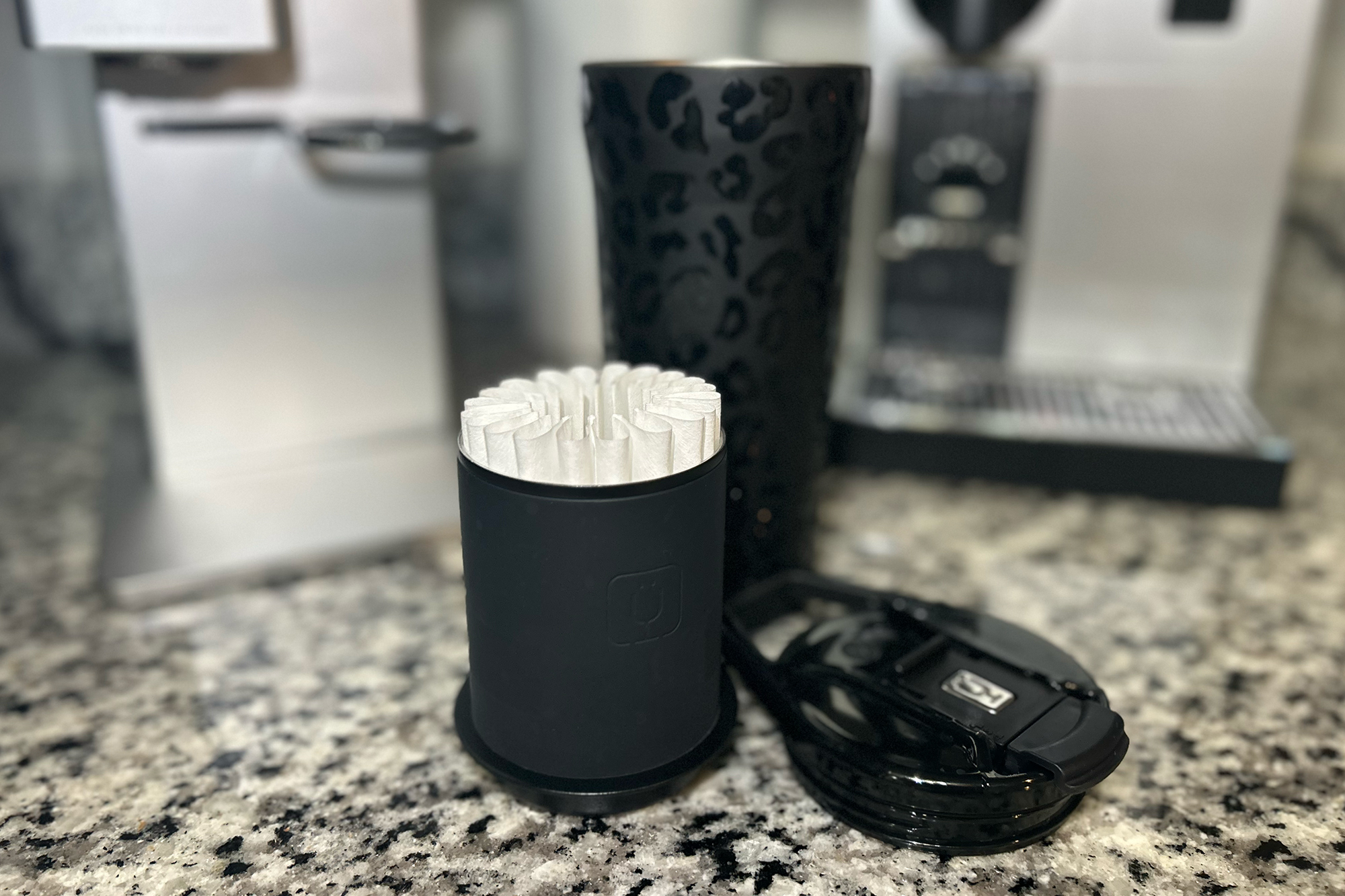 BruMate pour-over travel tumbler in Black Onyx Leopard print on a counter with Nespresso and XBloom machines