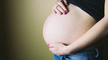 pregnant person holding their belly