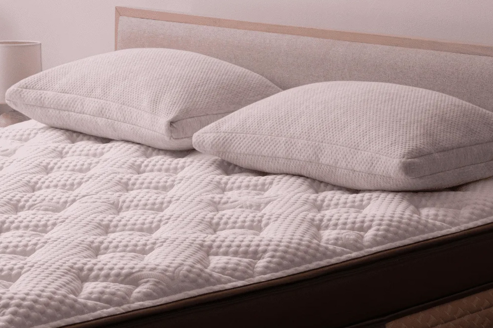 The Helix Midnight Elite Mattress, which features a quilted white cover and two white pillows on top.