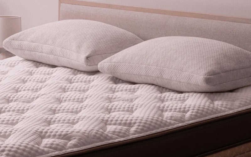 The Helix Midnight Elite Mattress, which features a quilted white cover and two white pillows on top.