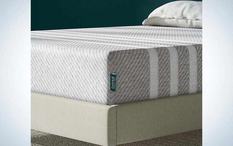 A side shot of the Leesa Original mattress, which is tan with stripes and has two pillows on top.
