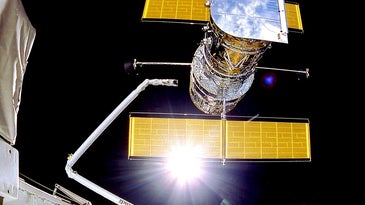 The Hubble Space Telescope, with its yellow solar panels featured prominently.