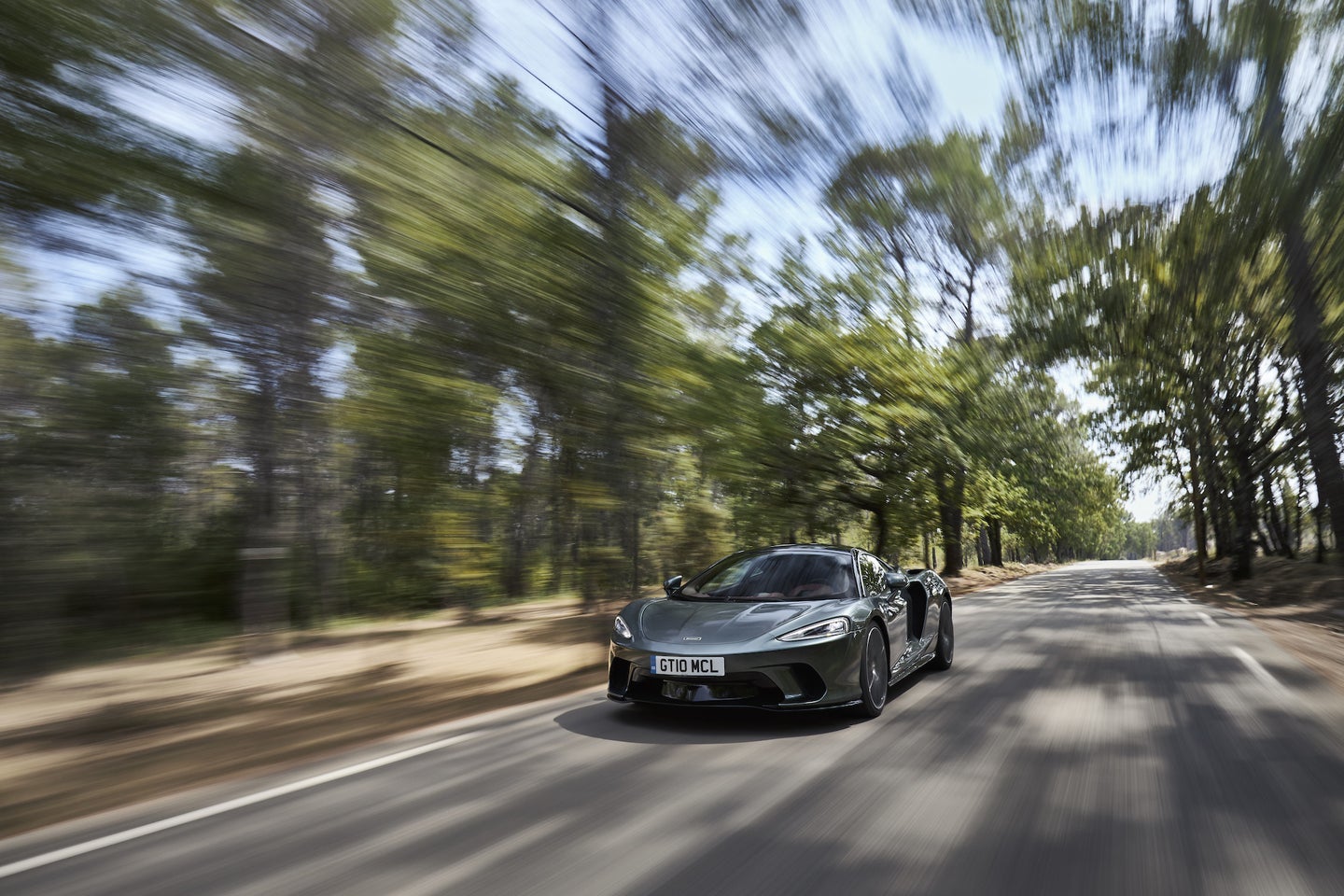 A Mclaren GT supercar driving on the road