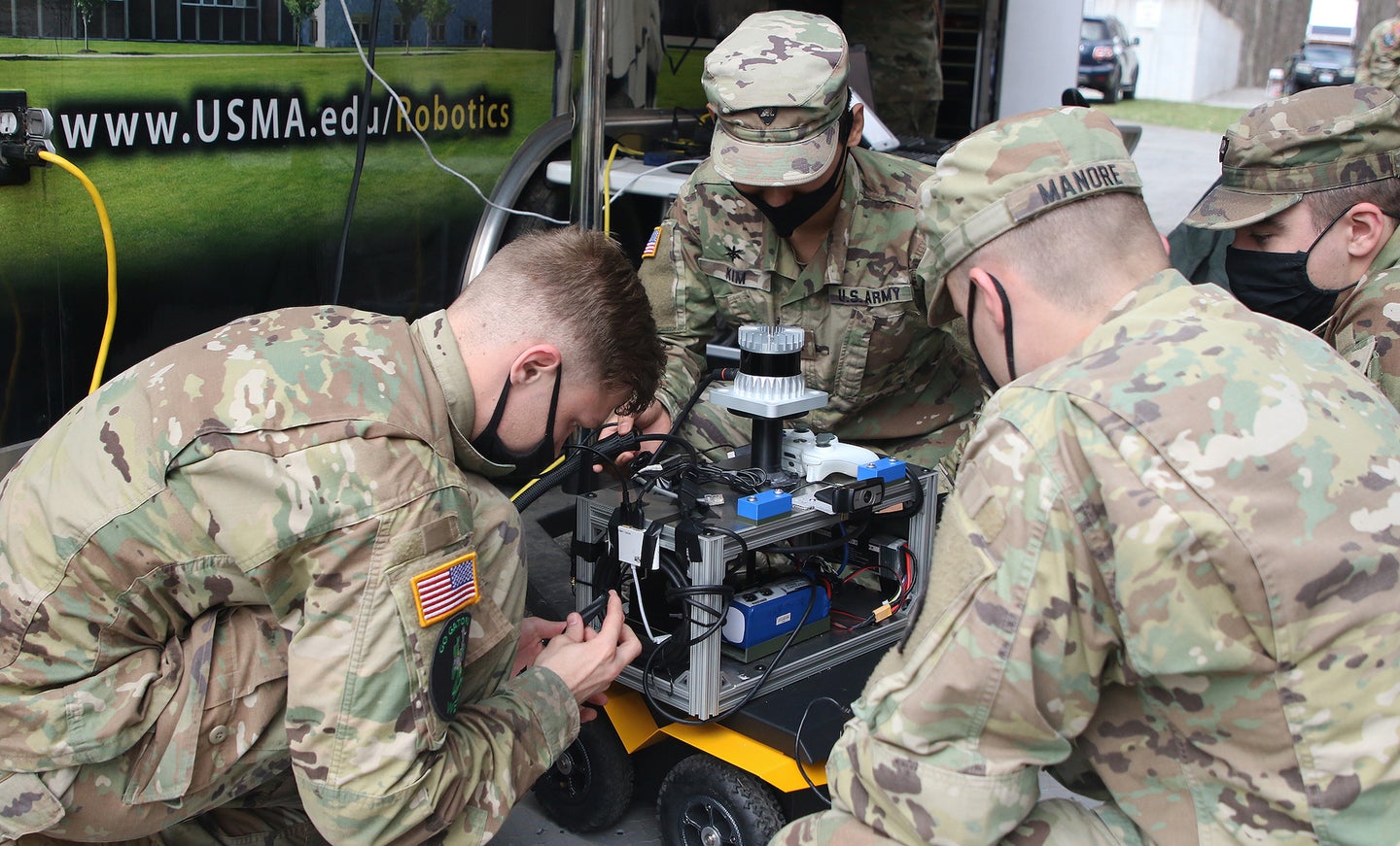 Soldiers work on a robot