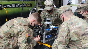 Soldiers work on a robot