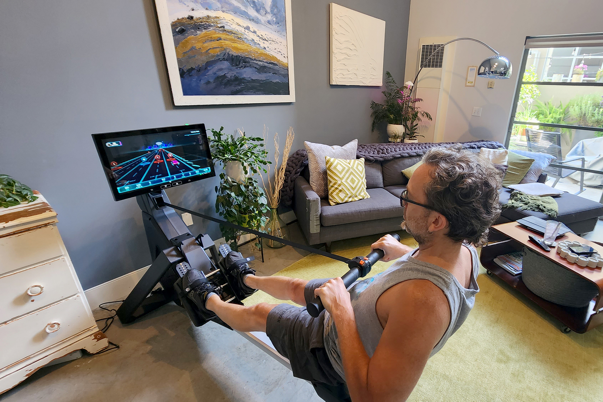 Markkus Rovito using the Aviron rowing machine in his loft living room