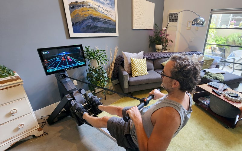 Markkus Rovito using the Aviron rowing machine in his loft living room