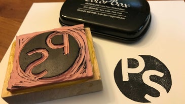 A homemade DIY rubber stamp made in the image of the Popular Science magazine logo.