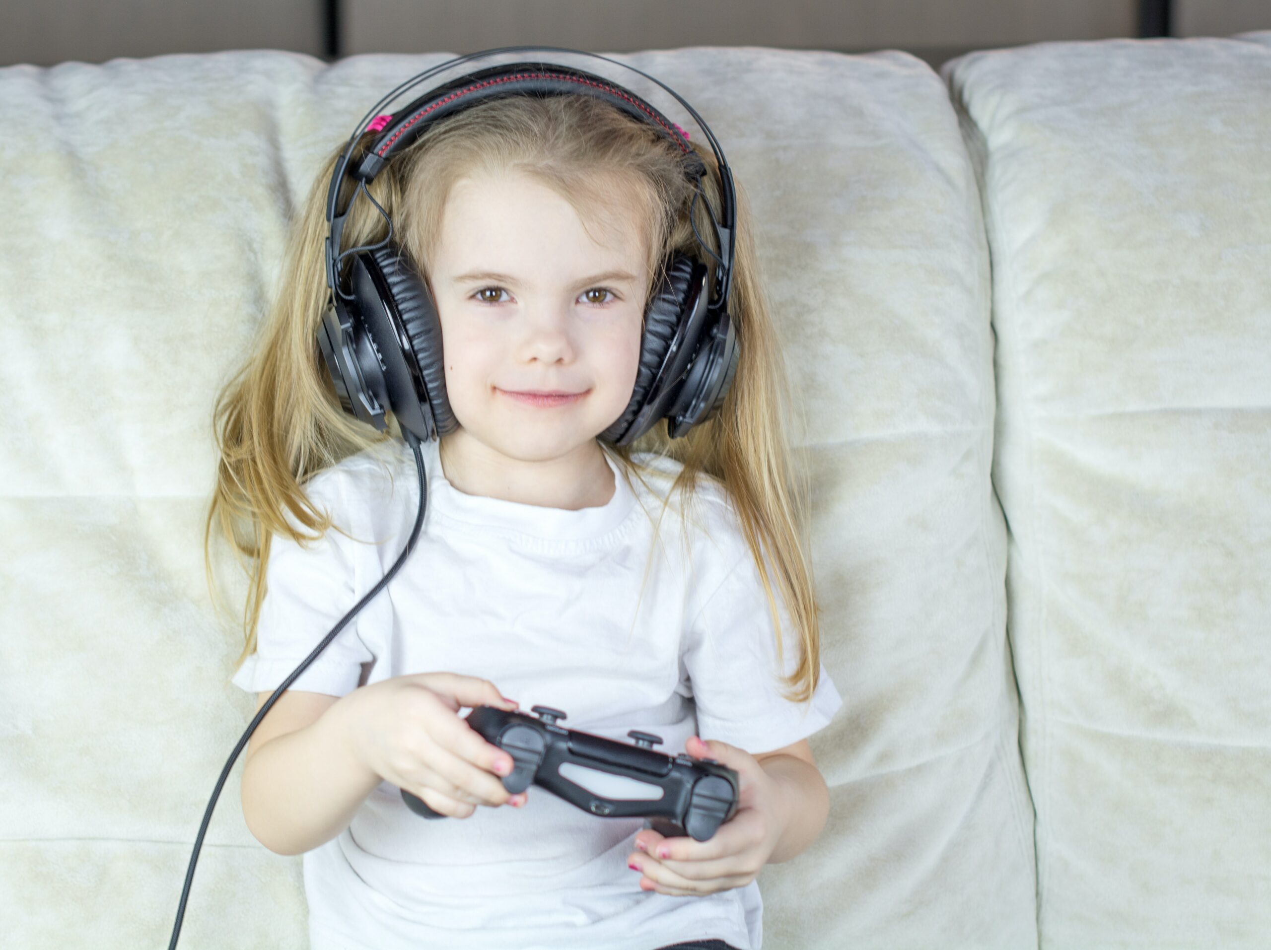 A child with headphones playing video games