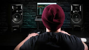 DJ/producer in a home studio with JBL monitors