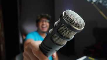 Smiling man holding microphone toward camera