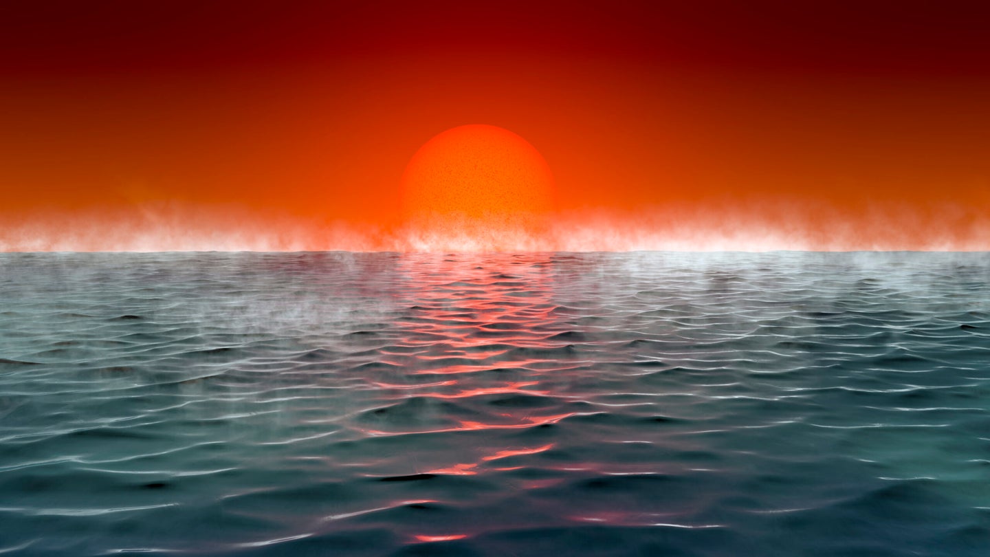 An illustration of a dramatic sunrise on a "Hycean" planet, with a very reddish-orange sun and skyline against a steamy, dark blue ocean.