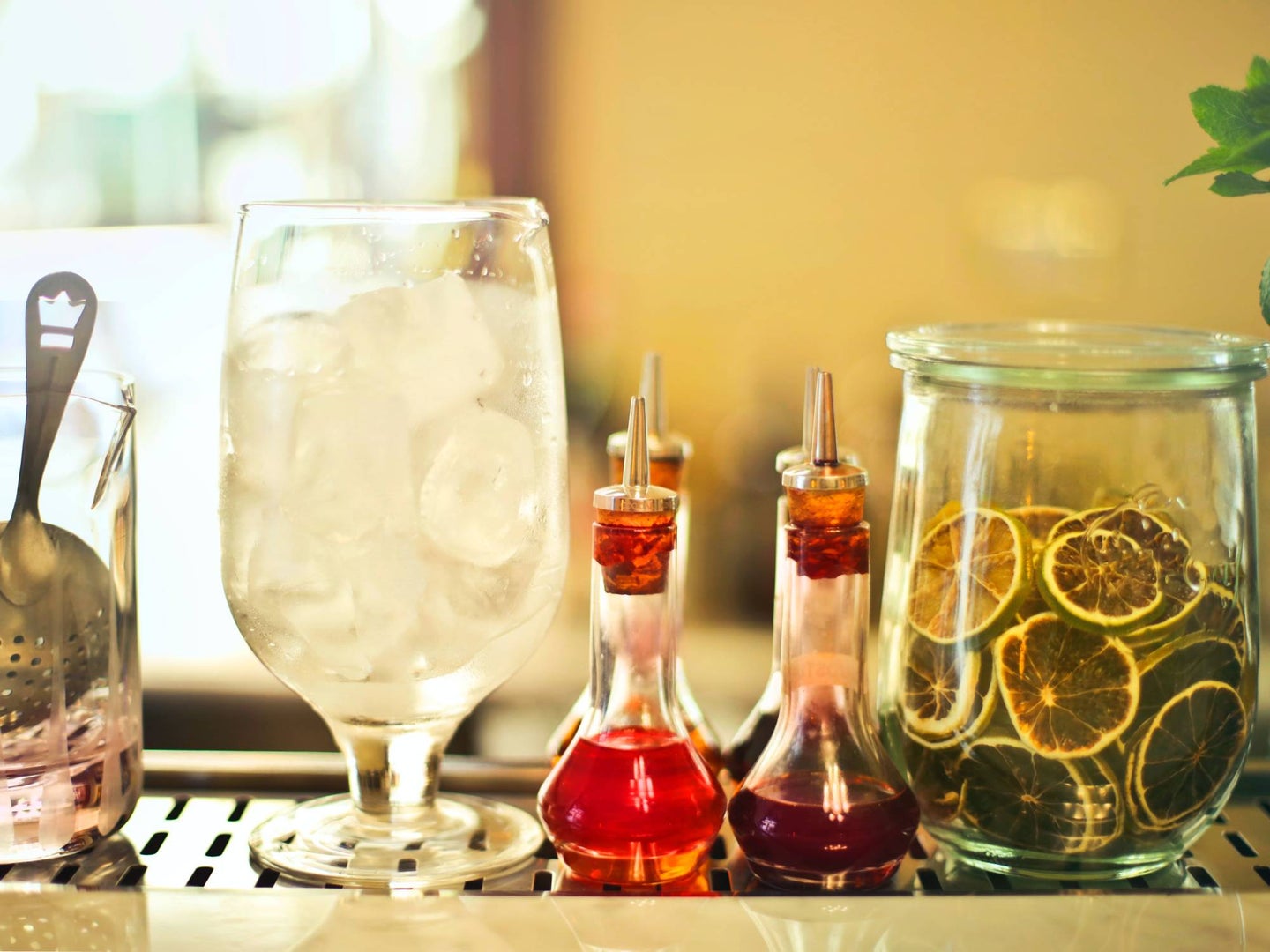 A bar cart with lined-up bottles of infused syrup.