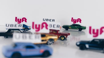 Uber and Lyft signs on tiny cars.