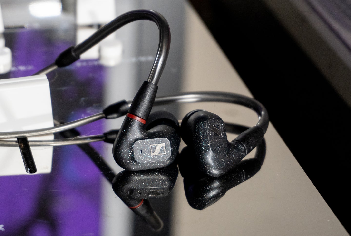 Sennheiser IE 300 earphones on a reflective mixer