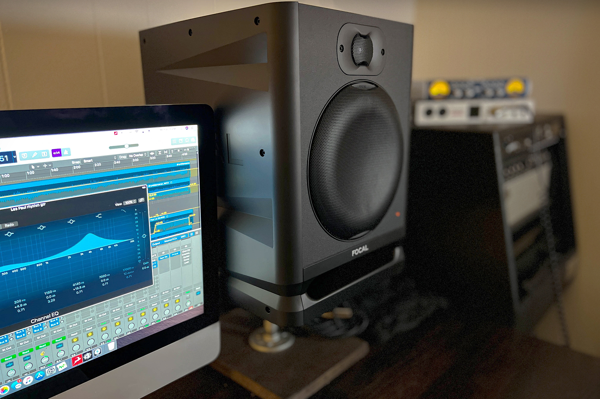 The Focal Alpha 80 Evo studio monitor sits gracefully on a stand next to a computer in a refined studio