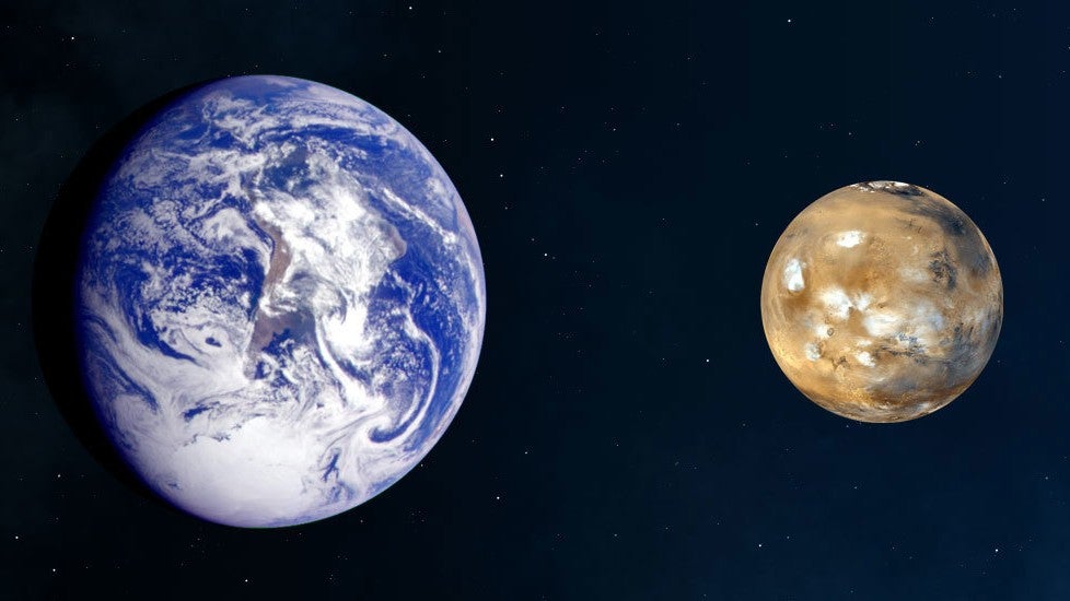 An illustration of Earth next to Mars, comparing sizes. Earth is bigger.