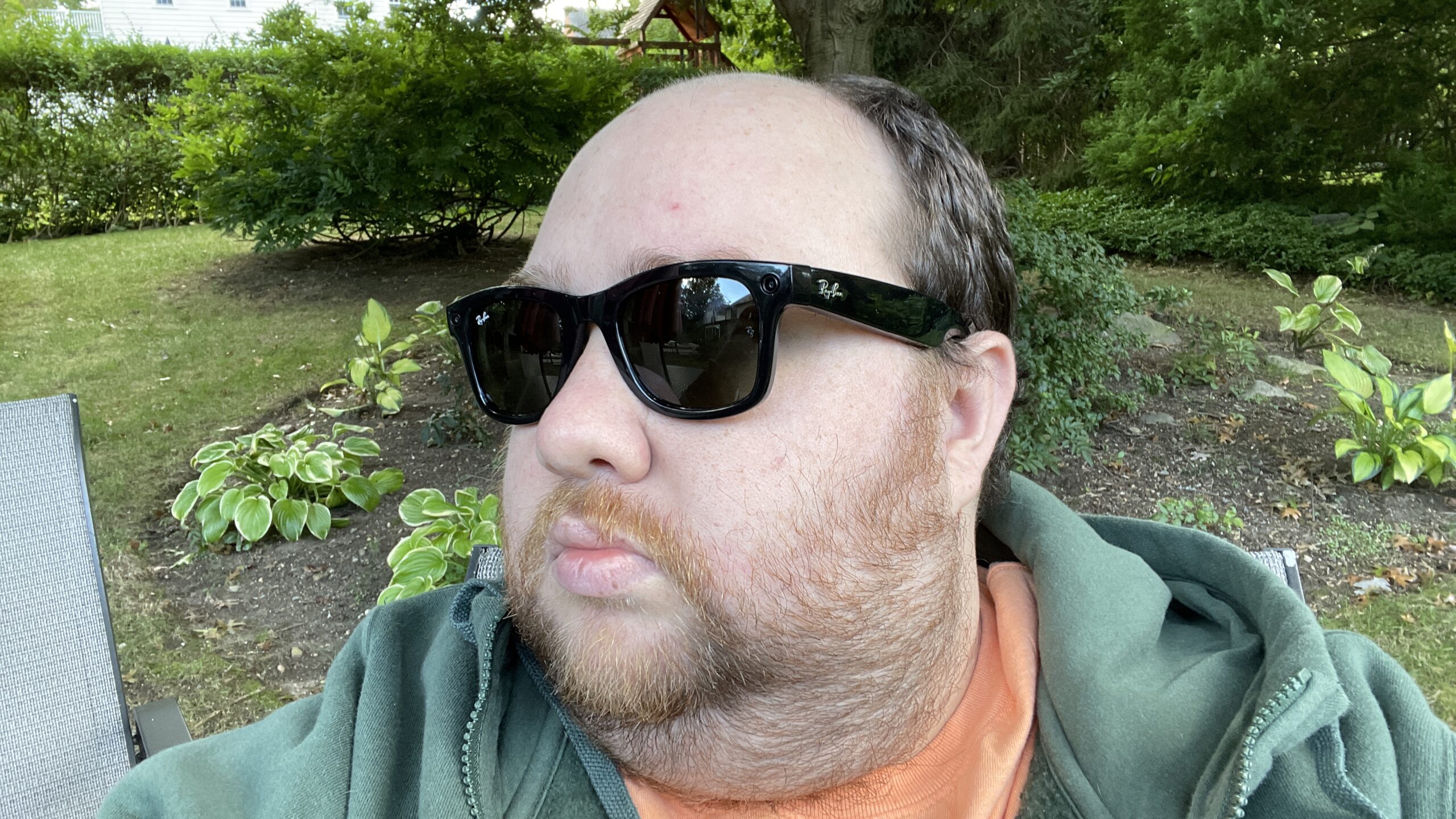 A man wearing Ray-Ban stories sunglasses in a garden
