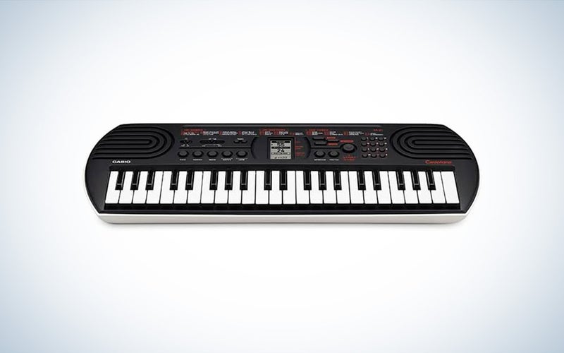 The Casio SA-81 beginner keyboard is placed against a white background with a gray gradient.