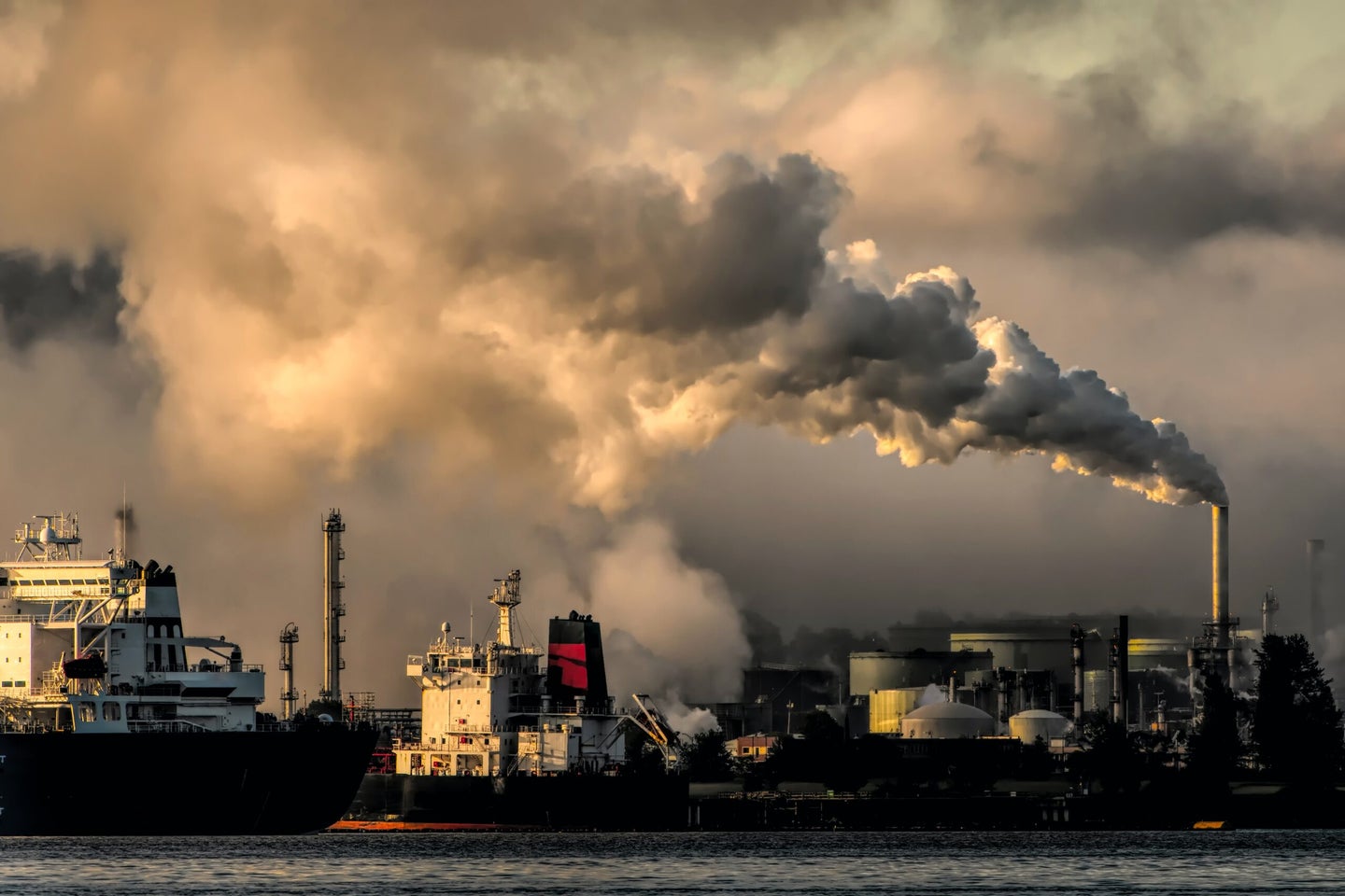 Smoke stacks emit greenhouse gas emissions that fuel climate change over a city waterfront