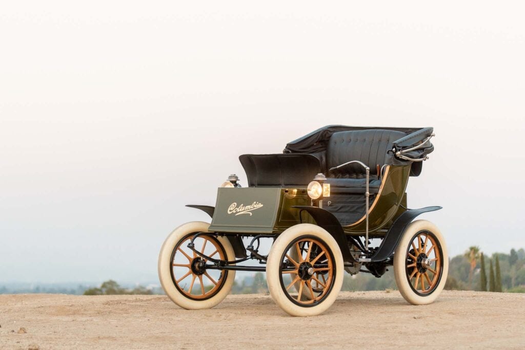 Front of the 1908 Columbia Electric Victoria Phaeton in olive green with white, wooden wheels