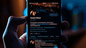 hand holding smartphone showing twitter on the screen
