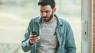 Person looking at phone reading indoors