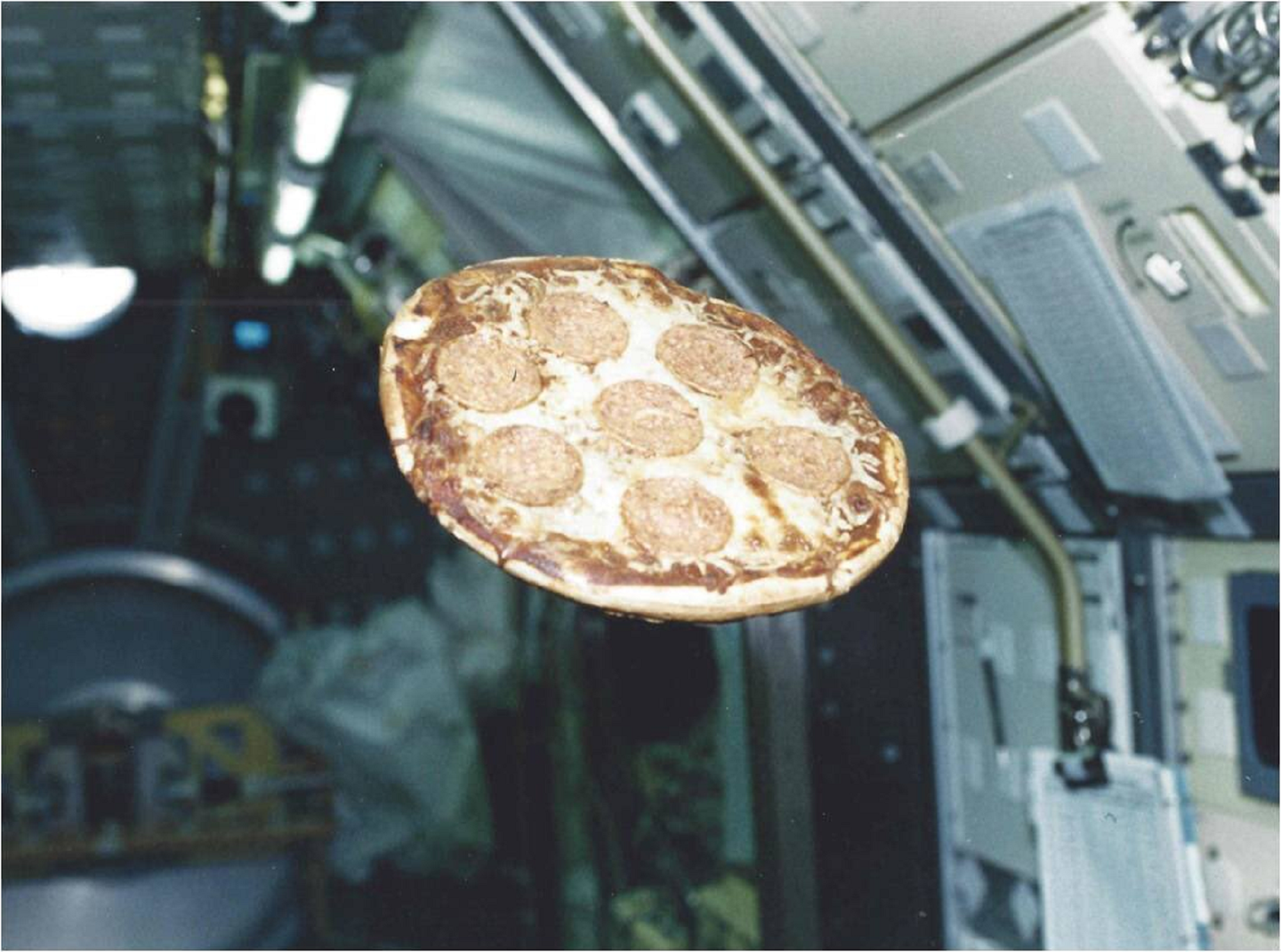 Pepperoni pizza floating in the Space Shuttle Columbia from NASA