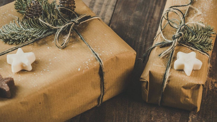 holiday gifts wrapped in brown paper with pine needles