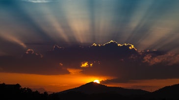 A sun rising over a mountain in Spain.