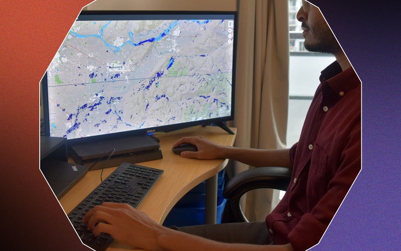World Flood Mapping Tool being used on a desktop computer by an engineer in a red shirt and glasses on a black, red, and purple background